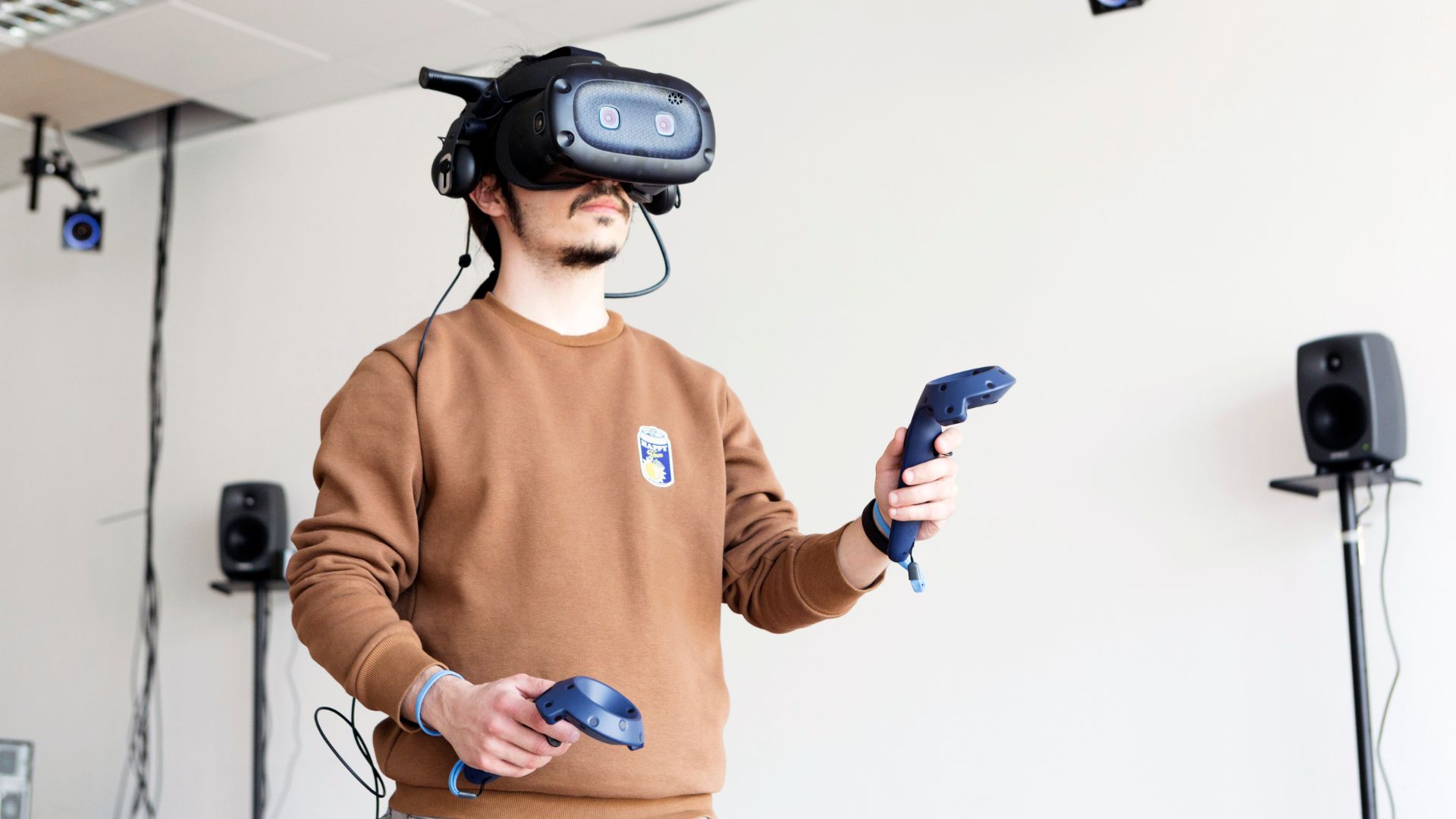 Studente con visore e controller nel laboratorio di interazione multisensoriale per ricerca su realtà virtuale e interfacce immersive