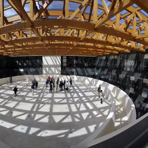 Veduta aerea dell'aula studio "Tazza" di lettere: una specie di terrazza interna, al quarto piano dell'edificio, sotto un tetto di vetro e capriate di legno.